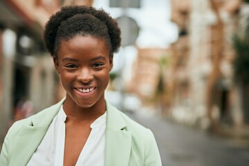 Fototapeta premium Young african american businesswoman smiling happy standing at the city