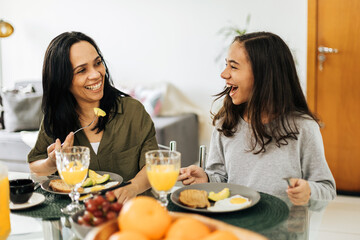 Single Parenthood. Mother and preteen daughter having breakfast at home.
