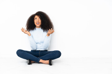 Young african american woman sitting on the floor frustrated by a bad situation