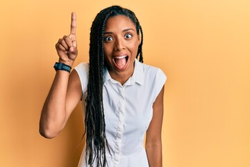 African american woman wearing casual clothes pointing finger up with successful idea. exited and happy. number one.