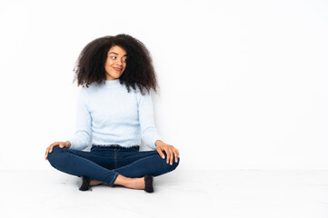 Fototapeta na wymiar Young african american woman sitting on the floor making doubts gesture looking side