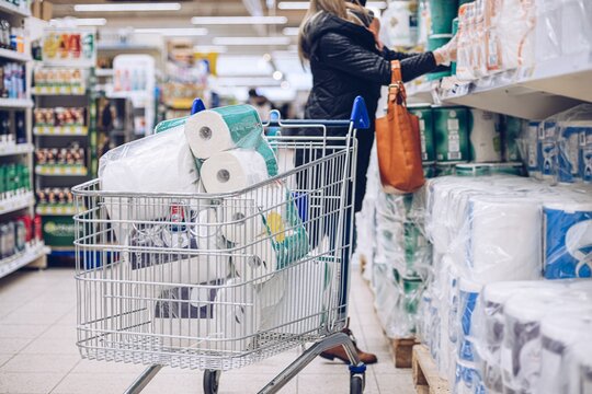 Woman Shopping At Supermarket Choosing Toilet Paper.