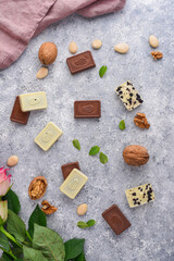 Chocolate background - pralines, flowers and walnuts