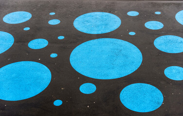 Blue polka dots on a black surface.