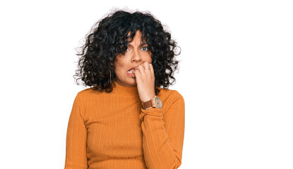 Fototapeta na wymiar Young hispanic woman wearing casual clothes looking stressed and nervous with hands on mouth biting nails. anxiety problem.