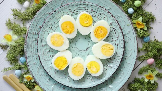 Easter table setting with flowers and eggs. Decorative plates with boiled eggs