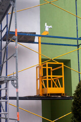 Yellow cradle on scaffolding