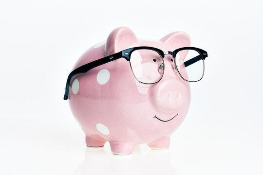 Funny piggy bank with glasses over isolated white background.