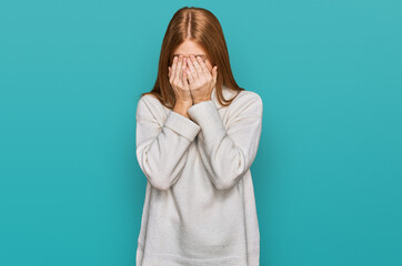 Young irish woman wearing casual winter sweater with sad expression covering face with hands while crying. depression concept.