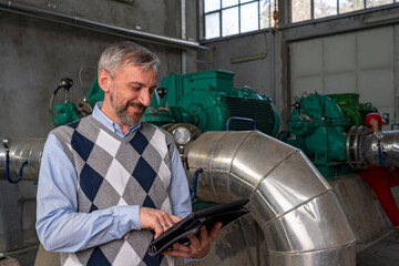 Smiling Technical Manager Using Digital Tablet in Mechanical Room - Industry 4.0