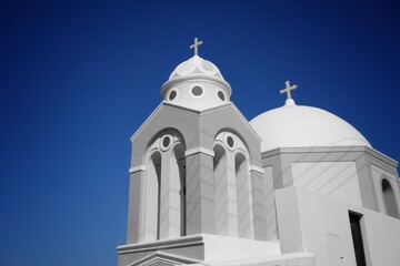 A beautiful whitewashed orthodox church in Santorini Greece and a blue sky