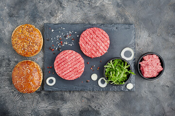 Fototapeta na wymiar Top view of burger ingredients on dark table