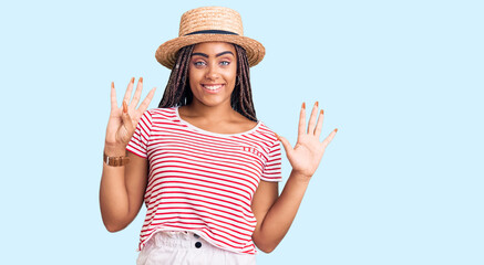 Obraz na płótnie Canvas Young african american woman with braids wearing summer hat showing and pointing up with fingers number nine while smiling confident and happy.