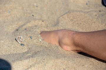 Close up of male feet in sand