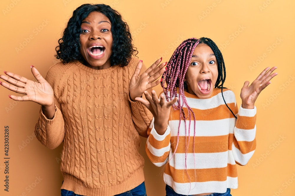 Sticker beautiful african american mother and daughter wearing wool winter sweater celebrating crazy and ama