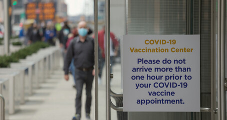 People walking into mass Covid 19 vaccination site place in New York City Javits Center