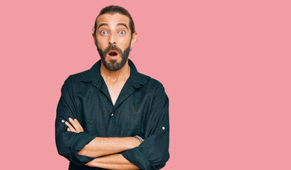 Attractive man with long hair and beard wearing casual clothes scared and amazed with open mouth for surprise, disbelief face