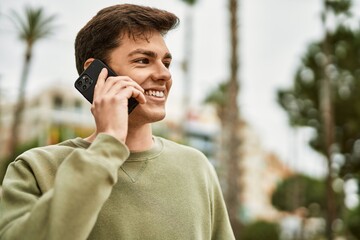 Young hispanic man smiling happy talking on the smartphone at the city.