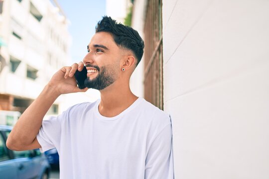 Young arab man with serious expression talking on the smartphone at the city.