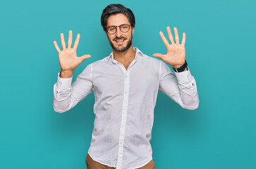 Naklejka premium Young hispanic man wearing business shirt and glasses showing and pointing up with fingers number ten while smiling confident and happy.