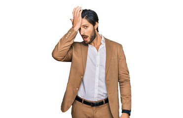 Young hispanic man wearing business clothes surprised with hand on head for mistake, remember...