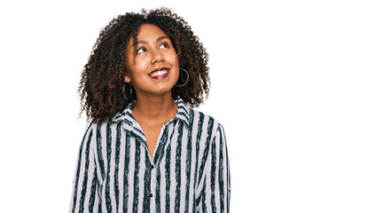 Young african american girl wearing casual clothes looking away to side with smile on face, natural expression. laughing confident.