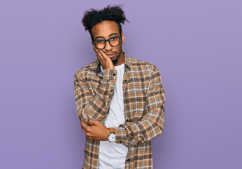 Fototapeta na wymiar Young african american man with beard wearing casual clothes and glasses thinking looking tired and bored with depression problems with crossed arms.