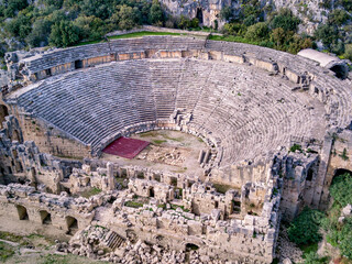 High angle drone aerial view of ancient greek rock cut lykian empire amphitheatre and tombs in Myra...