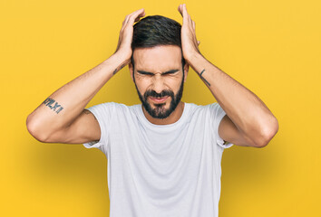 Young hispanic man wearing casual white t shirt suffering from headache desperate and stressed...