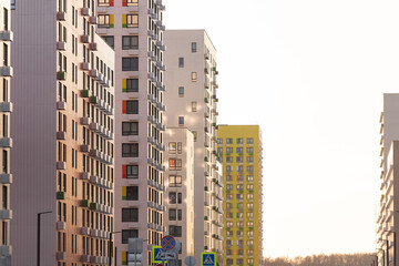 High-rise buildings under the bright sun. New areas of Moscow are growing up. Houses against a bright sky.
