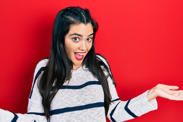 Young hispanic girl wearing casual clothes clueless and confused expression with arms and hands...