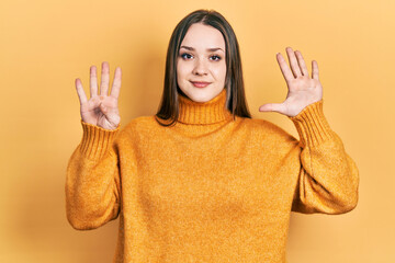 Young hispanic girl wearing casual clothes showing and pointing up with fingers number nine while...