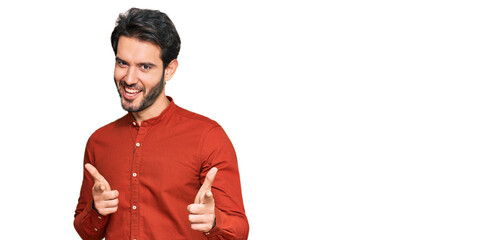 Young hispanic man wearing casual clothes pointing fingers to camera with happy and funny face. good energy and vibes.