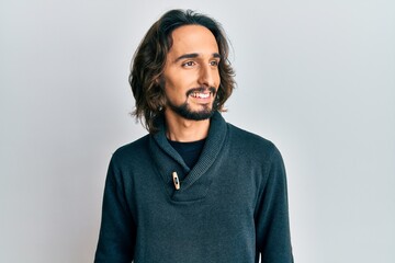 Young hispanic man wearing casual clothes looking to side, relax profile pose with natural face and confident smile.