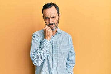 Middle age hispanic man wearing casual clothes thinking concentrated about doubt with finger on chin and looking up wondering