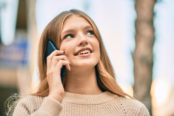 Beautiful caucasian teenager smiling happy talking on the smartphone at the city.