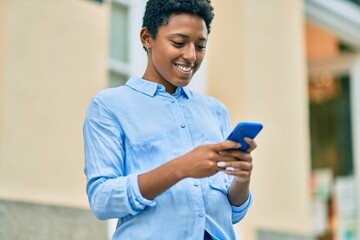 Young african american girl smiling happy using smartphone at the city.