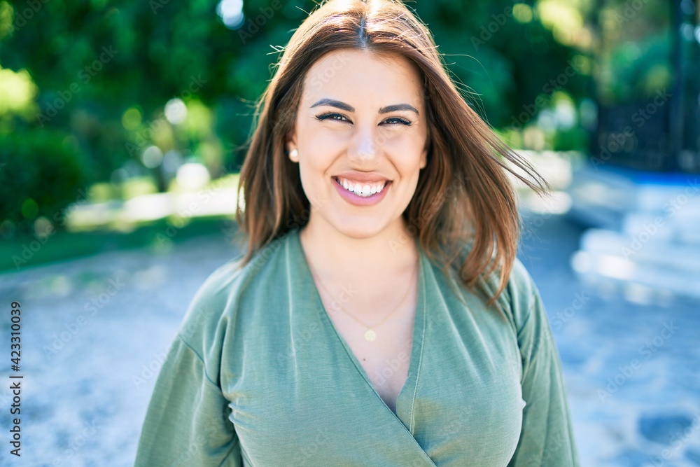 Wall mural Young hispanic woman smiling happy walking at street of city