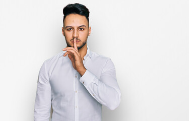 Young arab man wearing casual clothes asking to be quiet with finger on lips. silence and secret concept.