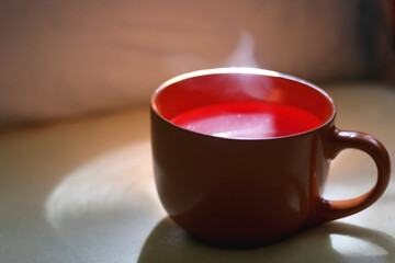 Cup of warm tea on a bed. Selective focus.