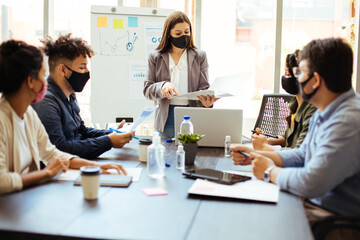 Business team wearing protective masks while meeting in the office during the COVID-19 epidemic