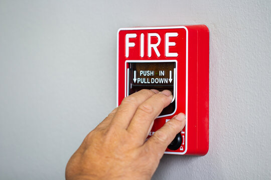 Fire alarm switch, The hand of man is pulling fire alarm on the wall, Hand push Fire alarm botton.
