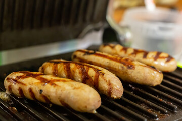 barbecue pork sausages with grilled stripes fried on a dark background