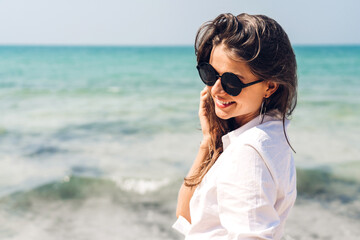 Portrait of smiling fashion woman relaxation on the tropical beach.Happy young beautiful girl enjoying and having fun on the tropical island.Summer vacations