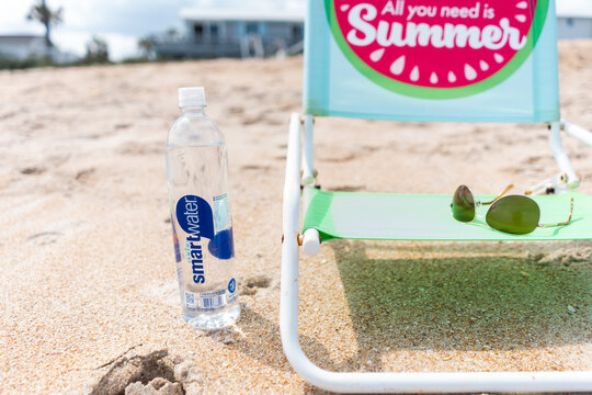 Smartwater plastic water bottle in the sand near beach chair on March 26, 2021 in St. Augustine Florida