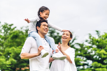 Portrait of enjoy happy love asian family father and mother holding cute little asian girl child smiling playing and having fun moments good time in summer park at home - Powered by Adobe