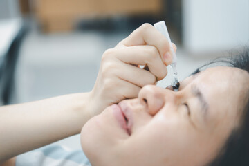 Obraz na płótnie Canvas Woman use eye drop, artificial tears to the eye