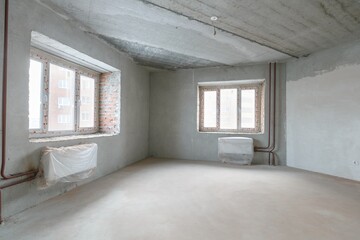 Obraz premium interior of the apartment without decoration in gray colors. rough finish