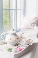 Morning tea near a window. Tea pot and a cup. Tender beautiful blue decor