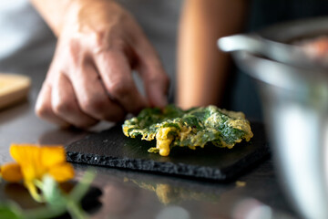 Obraz na płótnie Canvas main en train de placer une feuille frite sur une ardoise stylisme culinaire